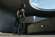 Vorderansicht von männlichem Radfahrer, der in einer urbanen Landschaft auf seinem Fahrrad fährt