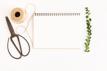 Wall Mural - blank notebook and scissors on white background, top view image of white notebook and empty space fo