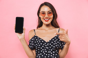 Poster - Woman isolated over pink background showing display of mobile phone.