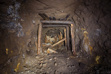 Underground abandoned gold iron ore mine shaft tunnel gallery passage with timbering wooden