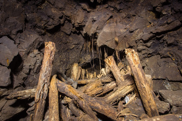 Underground abandoned gold iron ore mine shaft tunnel gallery passage with timbering wooden