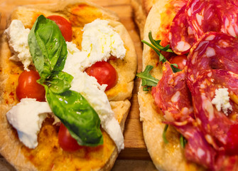 Wall Mural - Italian focaccia with Pepperoni, basil leaf and cheese on a rustic wooden table closeup. Pizza Ready to Eat. Top view