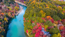 Aerial View Boat On The River Bring Tourist People To Enjoy Autumn Colors Along Katsura River To Arashiyama Mountain Area During Fall Season In Arashiyama, Kyoto, Japan.