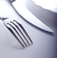 Wall Mural - Empty plate with knife and fork on a white background