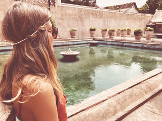 Wall Mural - Beautiful attractive woman standing near old swimming pool.