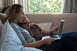 © Wavebreak Media - Lesbian couple using laptop on sofa