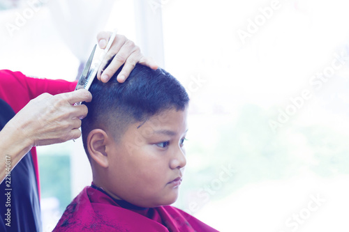 Barber Shop Hairdresser Makes Hairstyle To A Asian Boy With Hair