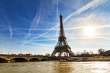 Fototapeta Paryż - Beautiful backlit Eiffel tower at the Seine river with a dramatic sky in winter