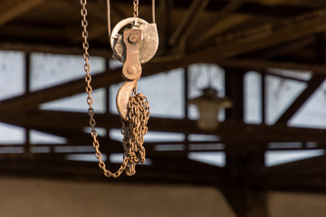 an iron hook on a pulley and a chain in the workshop