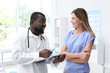 © New Africa - Young African-American doctor consulting patient in modern hospital