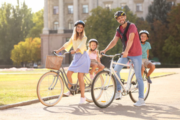 Wall Mural - Happy family riding bicycles outdoors on summer day