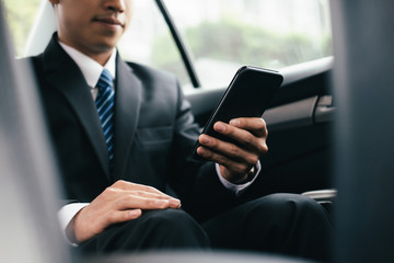 Young business man with phone in car.