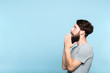 © golubovy - man looking sideways and is amazed or impressed by smth on the left. free space for advertisement or text. portrait of a bearded guy on blue background.