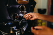 Close up of a woman hands pouring coffee beans into roaster