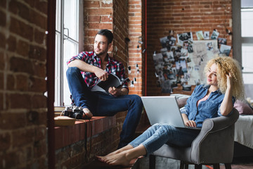 Handsome man and a woman in an armchair looking in the window.