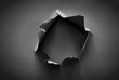 © tomertu - Black background with hole in the paper. Copy space.
