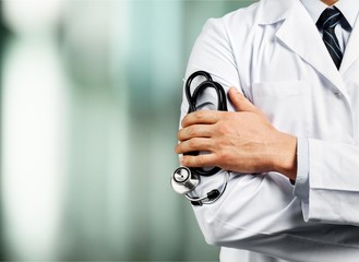 Wall Mural - Portrait of  doctor  with arms crossed in medical office