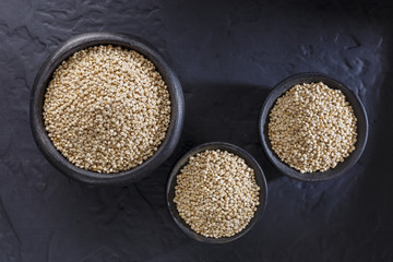 Wall Mural - Quinoa grains with spoon and bowl on black background