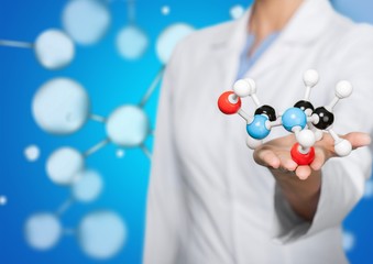 Wall Mural - Close up of Molecular structure model in hand on background