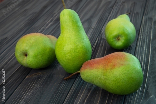 green ripe pear on black wooden background