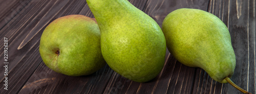 green ripe pear on black wooden background