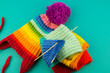 © Дарья Колпакова - Knitting a rainbow scarf and hat Blue background