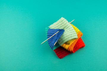 Knitting a rainbow scarf and hat Blue background