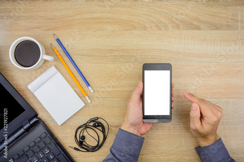 Man Using Smartphone With Office Work Essential Tools Items On