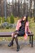 © satura_ - Fall, season and people concept - young woman sitting on a bench in park at autumn