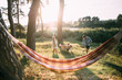 Young sympathetic family - mom, dad and son rest in nature, near a hammock