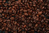Fototapeta Dinusie - Roasted brown coffee beans background. Flatlay style, messy pattern.