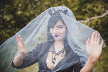 Gothic lady in a purple veil glamorous vintage look for Halloween. Beautiful citizen in vintage clothing pretty accessories of handmade work. Ideas for the Halloween holiday 