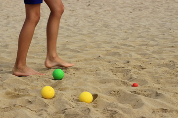 Coloured bocce balls sitting in the sand