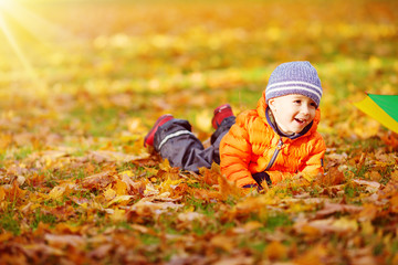 Child standing with umbrella in beautiful autumnal day