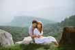 © TY Studio - Young couple sitting on the edge of mountains with a beautiful view