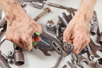 Poster - Dirty hand of worker with a wrench to tighten the nut closeup