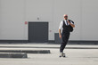 © Gennady Danilkin - Confident young businessman in business suit on longboard hurrying to his office, on the street in the city