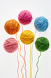 Collection of colorful woolen balls, partially unrolled.