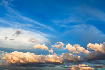 Wall Mural - white and yellow cumuli clouds in dark blue sky