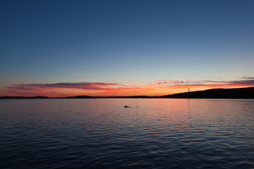 Wall Mural - Calm sunset and clouds over lake in finland