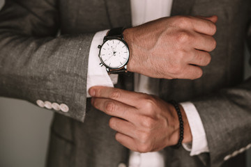 closeup fashion image of luxury watch on wrist of man.body detail of a business man.Man's hand in a grey shirt with cufflinks. Tonal correction 