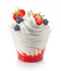 dessert of whipped cream and fresh berries in plastic cup isolated on white background