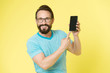 © be free - Man excited about new mobile opportunities. Guy eyeglasses cheerful pointing at smartphone. Man happy user interact application for smartphone. Guy bearded interact mobile interface application