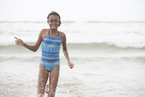 Beautiful curly haired mixed race pre-teen child in swim wear with