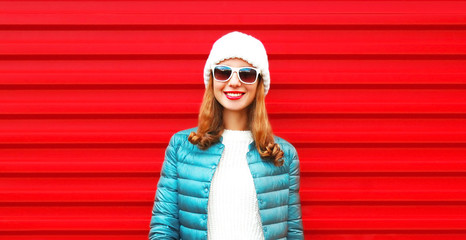 Wall Mural - Fashion portrait pretty smiling woman on a red background close-up