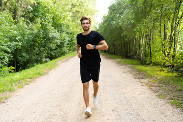 Athletic young man running in the nature. Healthy lifestyle