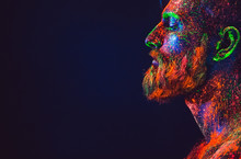 Concept. Portrait Of A Bearded Man. The Man Is Painted In Ultraviolet Powder.