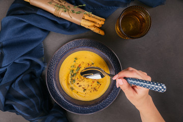 Wall Mural - Pumpkin soup in blue bowl topped with fresh herb