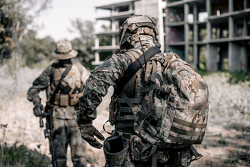 U.S. Marines are in the forest area near the destroyed building