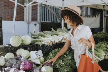 Wall Mural - Beautiful woman buying vegetables at a farmers market